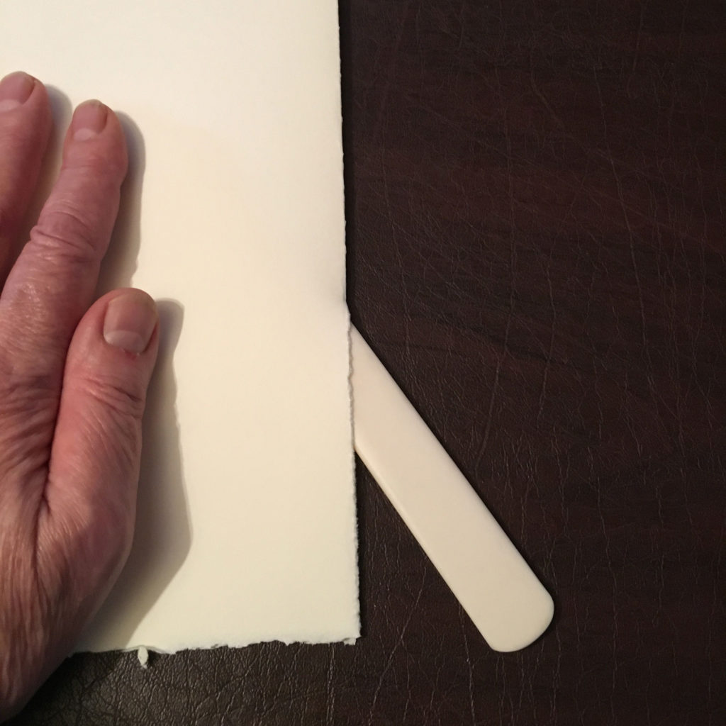 Tearing paper with a bone folder.